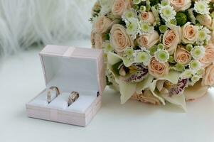nozze sposa e sposo anelli nel un' scatola su il tavolo foto