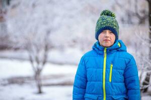 ragazzo nel blu giacca su il sfondo di nevoso città nel inverno nel nevicata foto