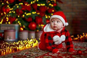 poco sei mese vecchio bambino vestito come Santa claus. sfondo per Natale carta. il bambino sembra giù a il posto per iscrizione. foto