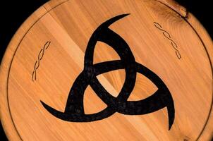 un' di legno piatto con un' celtico simbolo su esso foto