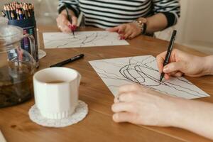 tver, Russia - febbraio 25, 2023. donna disegna neurografica a tavolo a un' psicologico sessione, neurografico matita disegno per rimuovere restrizioni, arte terapia foto
