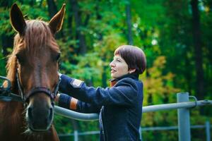 giovane bellezza ragazza comunicare con sua cavallo. donna equitazione un' cavallo al di sopra di tramonto su sfondo. foto