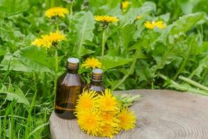 farmaceutico bottiglia di medicina nel erba contro sfondo di fioritura giallo fiore tarassaco officinale, o denti di leone . preparazione di medicinale impianti. pronto pozione di erba. foto