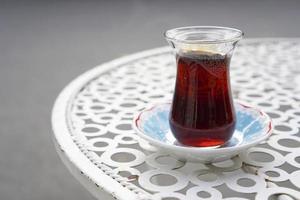 servito il tè su un bicchiere da tè turco su un tavolino di metallo in strada? foto