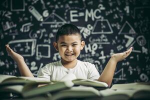 un ragazzo seduto in classe a leggere un libro foto