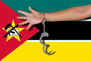 manette con la mano sulla bandiera del mozambico foto