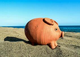 un' porcellino banca su il spiaggia foto