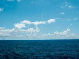 cielo azzurro e nuvole sopra l'oceano foto