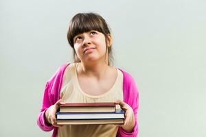 arrabbiato poco ragazza con libri foto