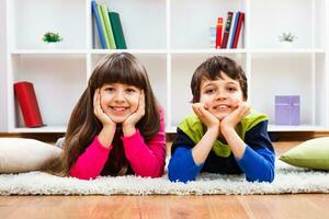 Due bambini posa su il pavimento foto