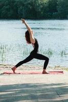 fit femminile pratica esercizio di yoga all'aperto foto