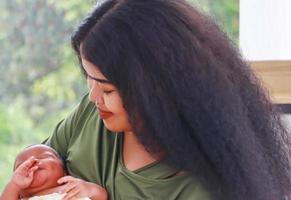 la madre sta allattando la mamma si è divertita a giocare felicemente con suo figlio appena nato, il concetto di amore e legami familiari. foto