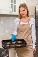 triste casalinga Tenere vassoio con bruciato biscotti foto