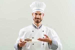 pasticciere è mostrando fette di torta su grigio sfondo foto