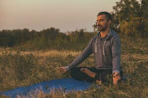 uomo fare yoga nel il natura foto