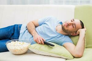 giovane uomo abbattere addormentato mentre Guardando tv foto