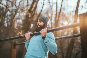 uomo è esercizio Tirare UPS nel il parco. foto