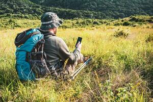 Immagine di escursionista utilizzando Telefono mentre la spesa tempo nel natura foto