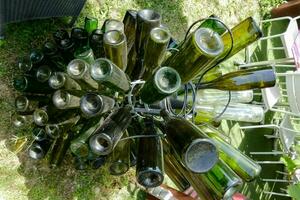 un' mazzo di vino bottiglie siamo seduta su il erba foto