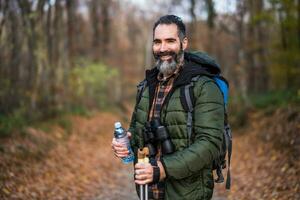 Immagine di uomo potabile acqua mentre escursioni a piedi foto