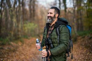 Immagine di uomo potabile acqua mentre escursioni a piedi foto