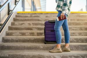Immagine di donna di gambe con valigia e biglietto in piedi su il le scale di treno stazione foto