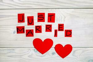 testo appena sposato e cuore forme su di legno tavolo foto