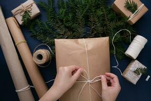 mani cravatta un' corda su un' Borsa con un' Natale presente su il blu sfondo foto