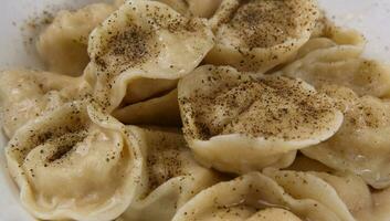 bollito carne Ravioli su un' piatto e cosparso con nero Pepe. selettivo messa a fuoco foto