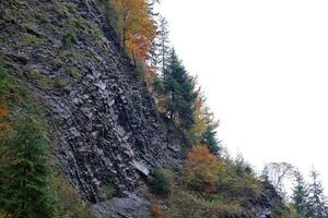 autunno rurale paesaggio con montagne picchi su sfondo foto