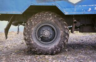 ruota avvicinamento nel un' campagna paesaggio con un' fango strada. fuori strada 4x4 suv automobile con ditry corpo dopo guidare nel fangoso strada foto