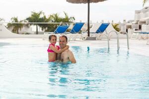 padre giocando con il suo figlia nel nuoto piscina foto