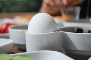 vicino uovo nel tazze per mattina prima colazione foto