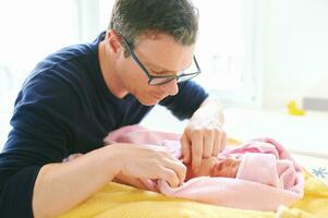 padre assunzione cura di neonato bambino, essiccazione ragazzo con asciugamano dopo tempo del bagno foto
