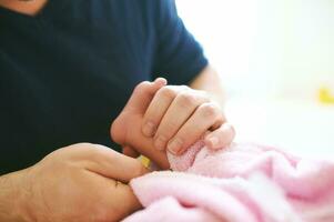 padre assunzione cura di neonato bambino, essiccazione ragazzo con asciugamano dopo tempo del bagno foto
