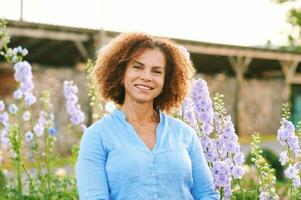 all'aperto ritratto di bellissimo 50 anno vecchio donna godendo simpatico giorno nel fiore parco o giardino, contento e salutare stile di vita foto