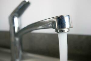 acqua scrosciante a partire dal un' rubinetto rubinetto lento movimento foto