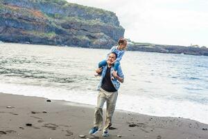 contento famiglia in piedi su il spiaggia su il alba tempo foto