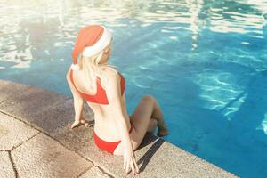 bella donna godendo sua Natale vacanze vicino il piscina. foto