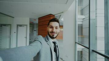 pov di giovane uomo d'affari nel completo da uomo assunzione un' autoscatto foto e avere divertimento nel moderno ufficio in casa