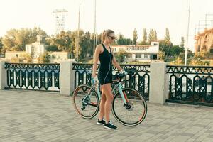 bellissimo ragazza con un' bicicletta, un' Telefono e cuffie foto