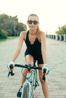 ragazza sorridente accanto sua bicicletta nel il parco foto