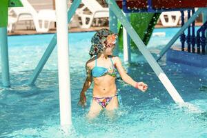 carino bambino piccolo ragazza giocando nel nuoto piscina foto