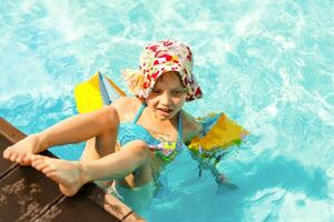 carino bambino piccolo ragazza giocando nel nuoto piscina foto