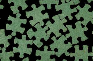 un' verde puzzle pezzo è mostrato su un' nero sfondo foto
