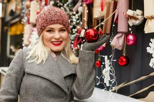 ragazza Selezione decorazione su un' tradizionale Natale mercato foto