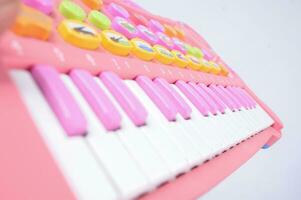 un' avvicinamento Visualizza di un' rosa bambini S giocattolo pianoforte con ordinatamente foderato chiavi e un isolato sfondo foto