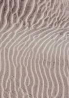il sabbia è coperto con increspature e modelli foto