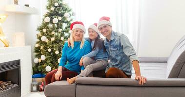 giovane famiglia su Natale mattina scambiare regali e godendo loro tempo insieme. foto