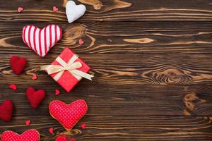 tema d'amore, cuori tessili disposti su una superficie di legno, una confezione regalo per san valentino foto